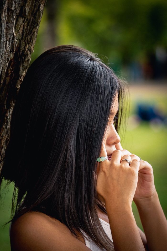 女人站在树旁抱着她的寺庙的侧视图照片