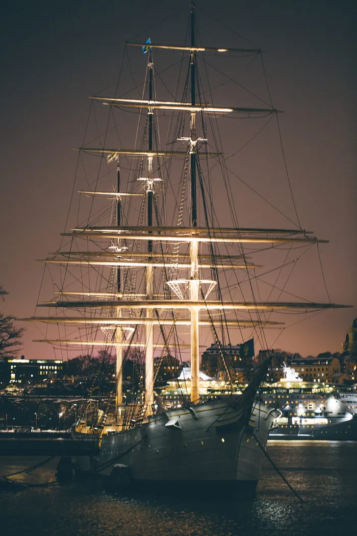 夜间建筑物附近有灯光的白色和棕色小船