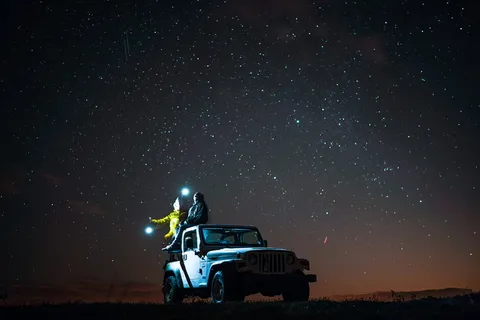 星空下坐在牧马人顶上的人 星空下坐在牧马人顶上的人