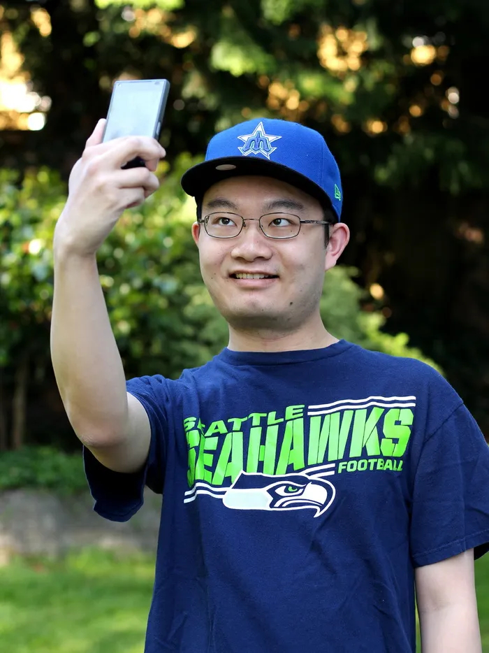 男士，蓝色，西雅图海鹰队圆领衬衫，手持，智能手机，男性，个人，年轻