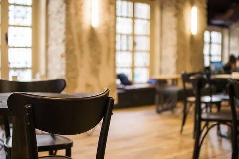 餐厅内摆放着黑色木制桌椅，配以黄色桌椅