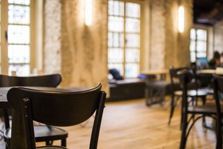 餐厅内摆放着黑色木制桌椅，配以黄色桌椅