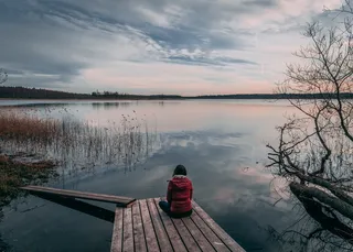 白天坐在灰色木质码头上的人