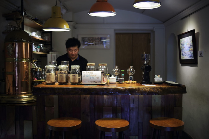 身穿黑色马球衫的男子站在吧台前