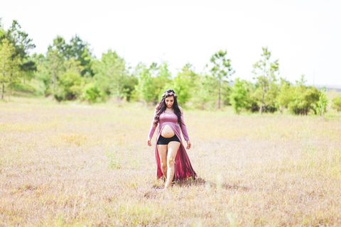 一名穿着开叉连衣裙的女性的孕妇照片