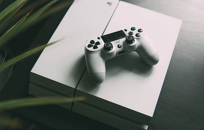 带无线控制器的白色索尼PS4控制台的选择性聚焦摄影
