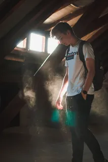 站在墙上被阳光照亮的男子 站在墙上被阳光照亮的男子