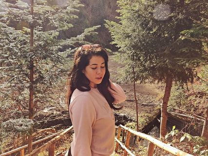 在木桥上穿着粉色长袖衬衫的女子