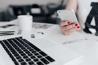 女商人在办公桌前使用手机