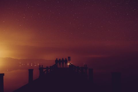 四个人站在码头上的剪影照片