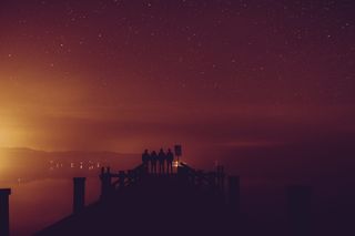 四个人站在码头上的剪影照片