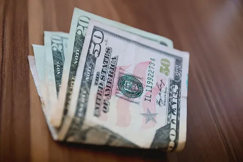 木桌上放着几美元