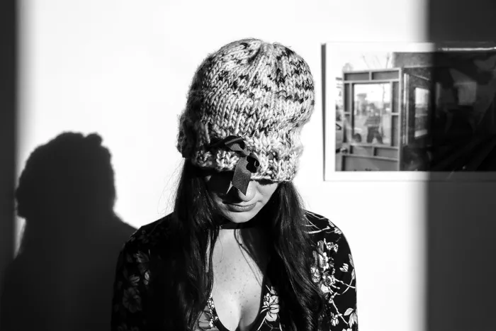 身穿针织帽子和花朵长袖上衣的女士的灰度照片