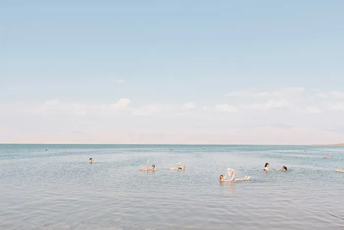 一群人白天在死海上游泳