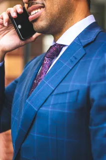 身着蓝色细条纹西装夹克的男子在打电话的特写照片