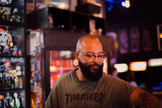 一名身穿灰色短袖圆领衬衫的男子站在商用冰箱旁