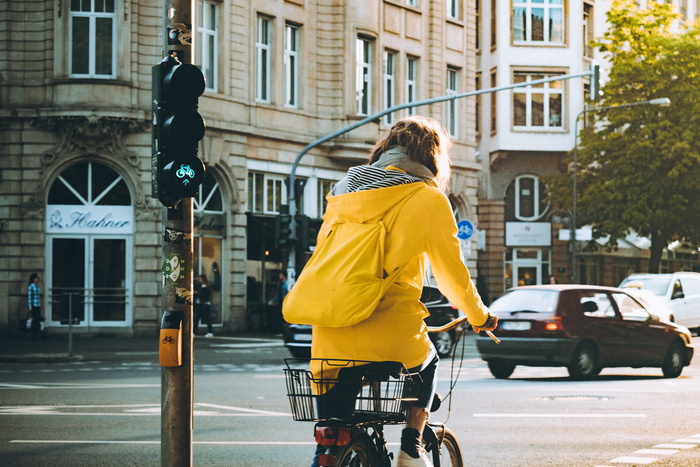 一名身穿黄色连帽外套的妇女正在骑自行车