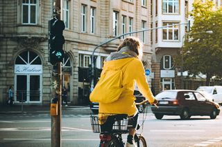 一名身穿黄色连帽外套的妇女正在骑自行车