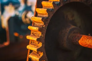 一个生锈的旧齿轮在阳光下的特写镜头。这张照片摄于英国肯特郡邓格内斯