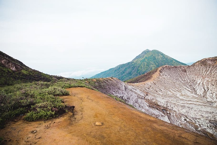 绿色的山丘和荒芜的石山，还有徒步旅行者