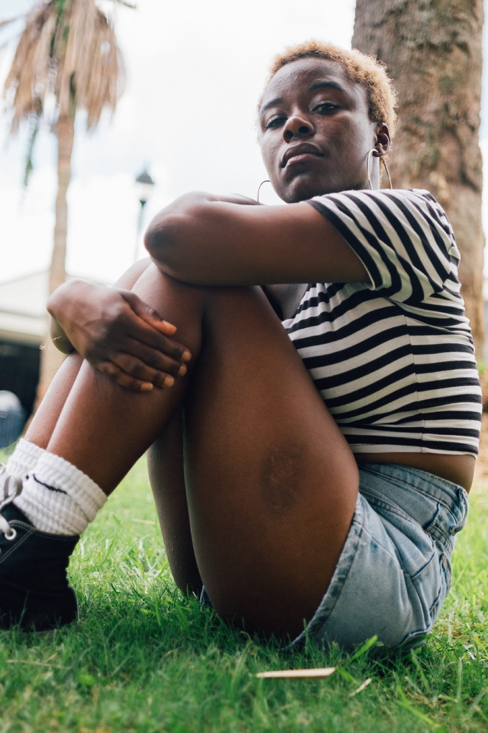 穿着条纹上衣坐在树旁的女人