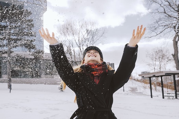 在公园里扔雪的女人照片