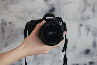 拿着黑色佳能 EOS 6D 的人