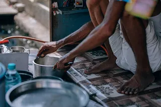 穿着白色短裤拿着不锈钢砂锅的人