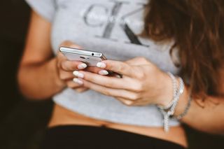 拿着白色手机的年轻女子