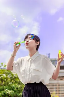 穿着白色上衣的女人玩泡泡的照片 穿着白色上衣的女人玩泡泡的照片