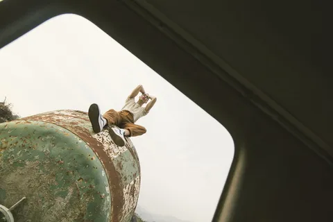 坐在绿色金属罐上的人