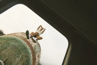 坐在绿色金属罐上的人