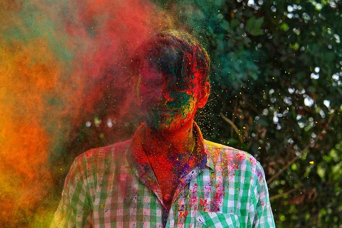 身穿绿色和白色格子纽扣的男子站在高高的绿树旁