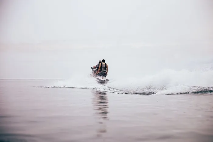 在阴天，摩托艇在海滩上制造波浪