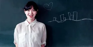 女人站在绿色混凝土墙后面