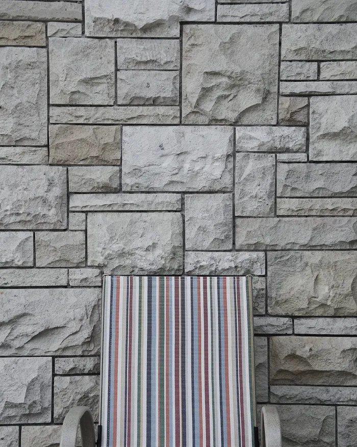 砖墙附近的灰色扶手椅