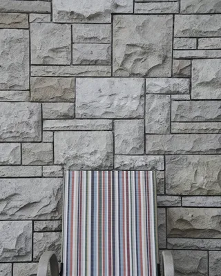 砖墙附近的灰色扶手椅