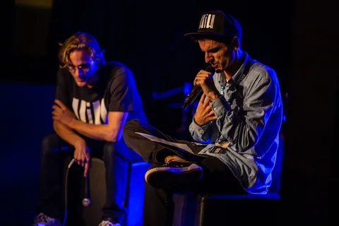 坐在奥斯曼脚凳上拿着麦克风的男子