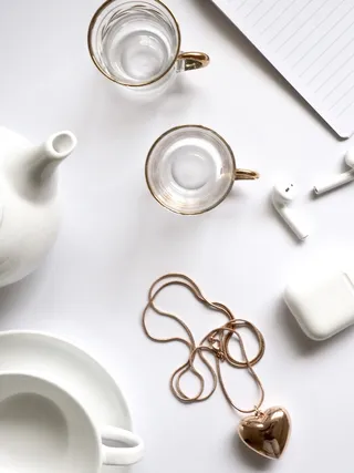 金色心形吊坠项链，在桌子上的两个玻璃杯子旁边