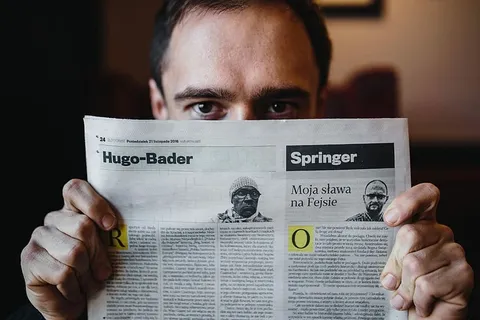 年轻的衣着优雅的男子坐在咖啡馆里