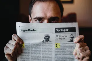 年轻的衣着优雅的男子坐在咖啡馆里