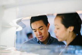 男子站在身穿黑色衬衫的女子旁边的特写照片