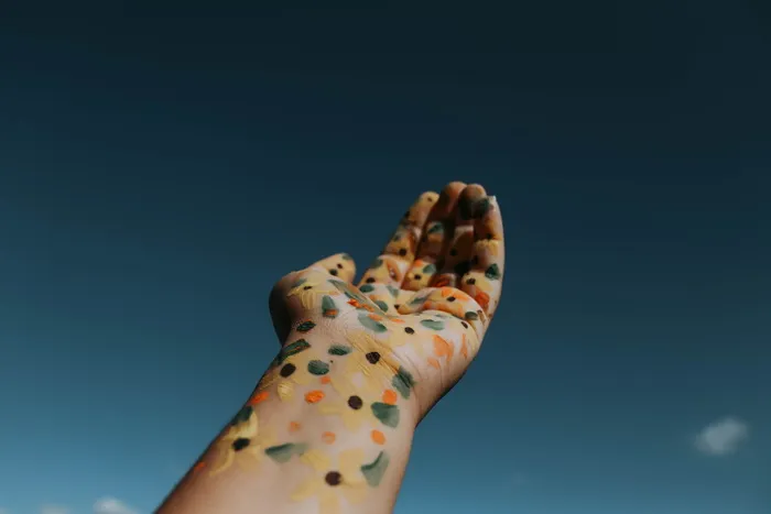 用花卉颜料举起左手的人