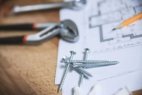 带有公寓平面图的特写螺丝和其他工具