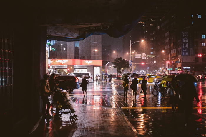 夜间走在人行道上的一群人