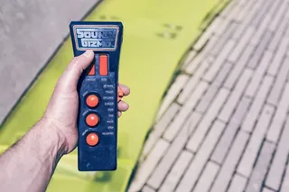 手持黑色和橙色声音Gizmo遥控器的人