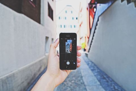 使用太空灰Iphone 5s的人白天拍摄大楼照片