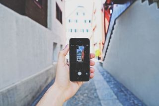 使用太空灰Iphone 5s的人白天拍摄大楼照片