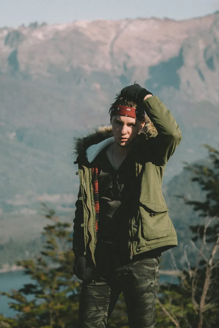 白天穿着绿色派克大衣的男人站在山上