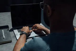 男子在桌上使用笔记本电脑